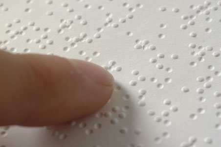 Ảnh chụp các ký tự chữ nổi Braille dập nổi trên giấy.